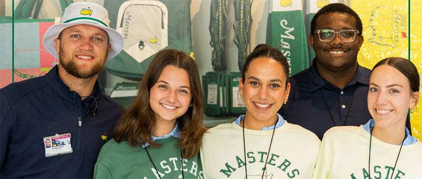 Five students pose while working at the Masters.