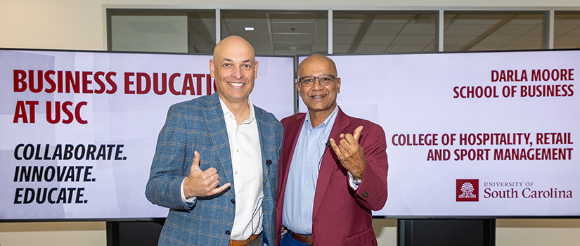 University of South Carolina deans Michael Sagas of the College of Hospitality, Retail and Sport Management and Rohit Verma of the Darla Moore School of Business celebrate the signing of a partnership agreement to expand graduate combination degree programs.