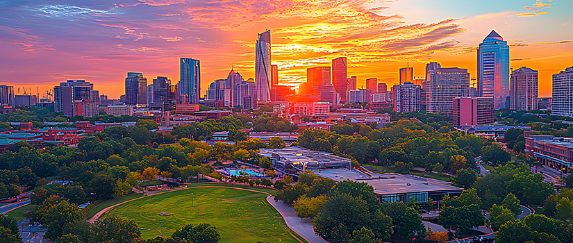 Sunset view of the Charlotte, North Carolina, skyline overlooking Uptown and surrounding green spaces.