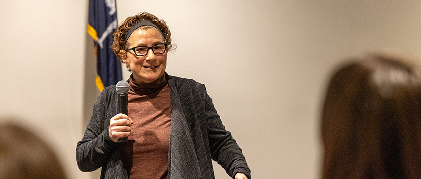 Michelle Delloso speaks to an audience during a presentation, sharing insights from her career as a pioneering athlete, sports marketer and advocate for women in sports.