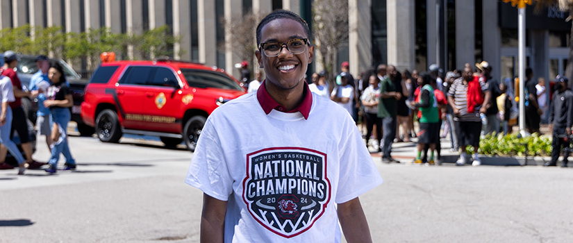 Branden Miller wearing a South Carolina women’s basketball national champions shirt while celebrating with fans in downtown Columbia.
