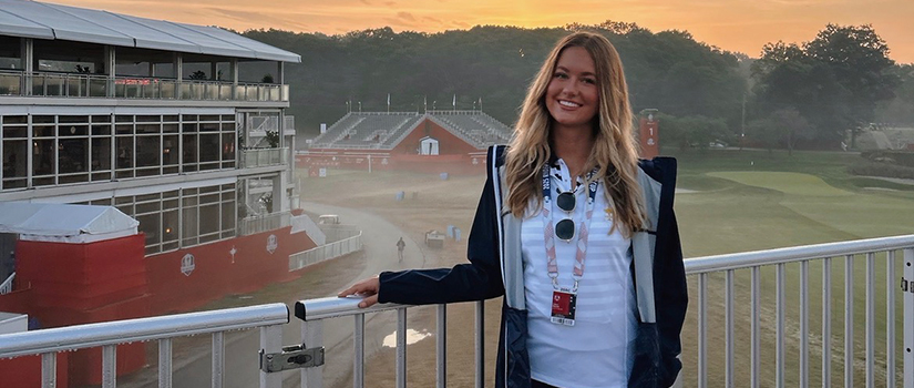 Kaila Regan stands overlooking a championship golf course at sunrise during a professional golf tournament.