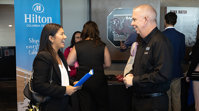 A student speaks with a representative from Hilton Hotels as the fall 2022 Experience Expo.