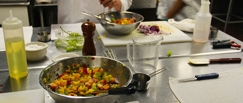 A colorful mixture of mango salsa is displayed on top of a cooking table in the culinary kitchen at McCutchen House.