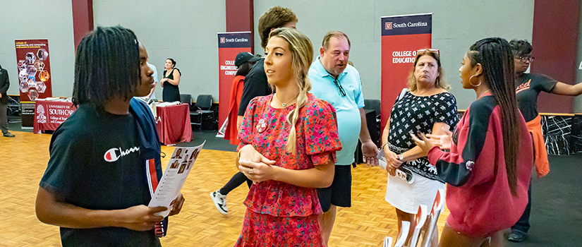 HRSM Leaders speak with prospective students at an Open House event.