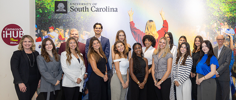 Group photo of the University of South Carolina Department of Retailing Student Advisory Board, featuring students and faculty standing together in front of a colorful Gamecock spirit mural.