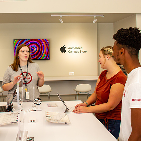 Sarah Fowler, iHub team leader, speaks with two students about Apple products.