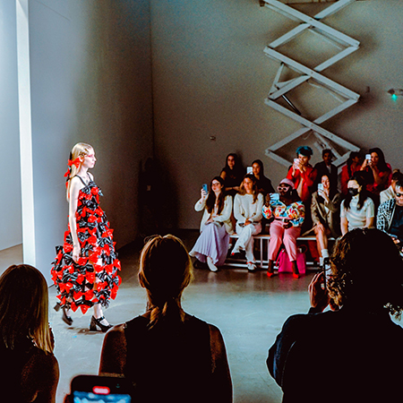 A model walks in front of a crowd taking pictures at New York Fashion Week in September 2022.