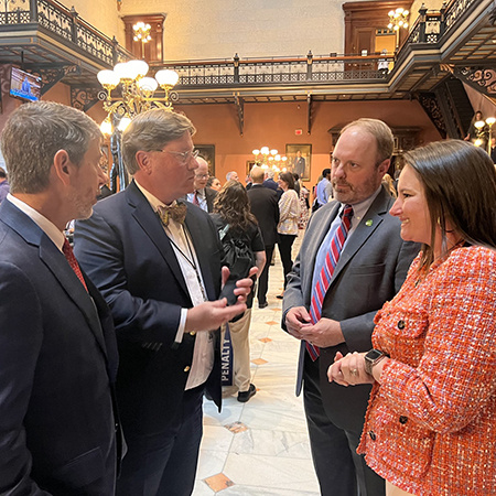 Nikki Crabtree Huber is pictured on the far right having a discussion with members of the South Carolina House of Representatives on the house floor.