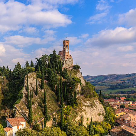 A clock tower in Emilia Romagna sits atop a hill