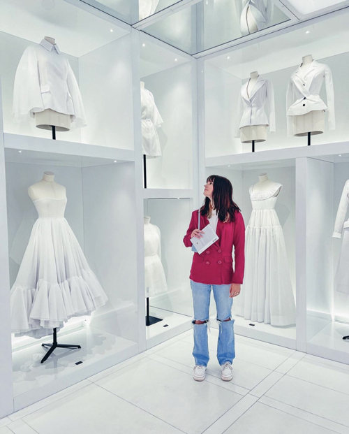 A person looks at all white clothing in a retail shop
