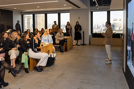 Students listen to a presentation from a member of the Ralph Lauren team