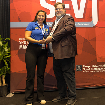 Emily Cole receives an award from Matt Brown