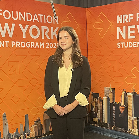 Retailing senior Abby Foy stands at the NRF Foundation Student Program stage in New York City.
