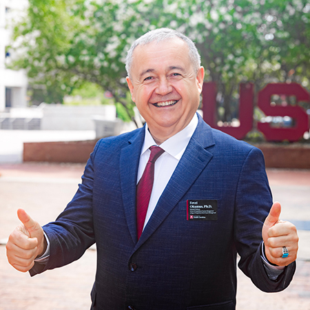 Fevzi Okumus, director of the University of South Carolina School of Hospitality and Tourism Management, smiles and gives two thumbs up.