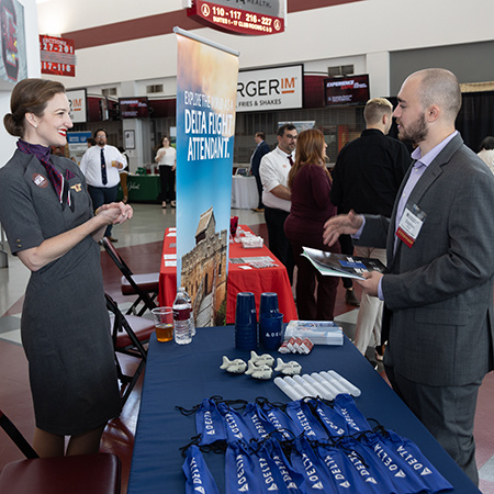 A Delta flight attendant representative speaks with a student at the Experience Expo event.