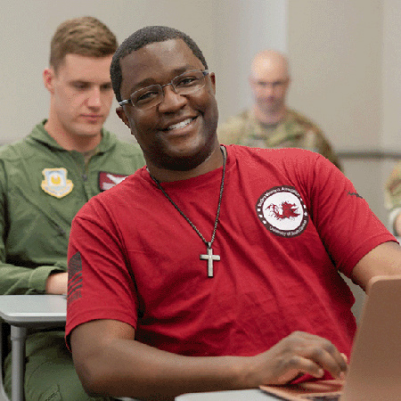 Student veteran sitting in a classroom smiling
