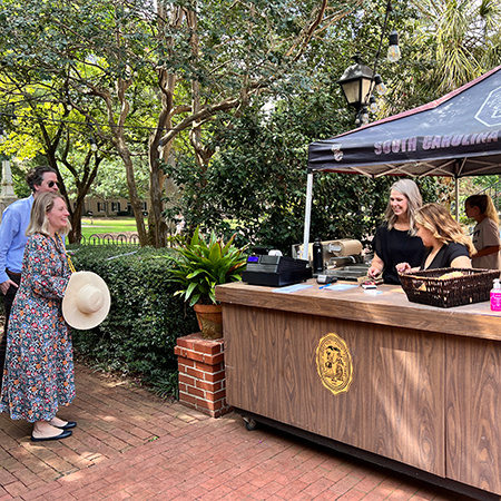Two customers speak with front desk reception at the Garden Grill.