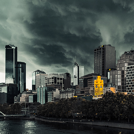 A city skyline with dark ominous clouds hovering in the sky above