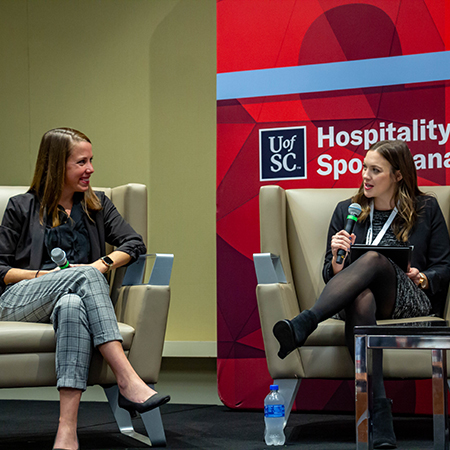 2022 SEVT keynote speaker Jessica O'Neill on stage with Ph.D. student Grace Kazmierski.