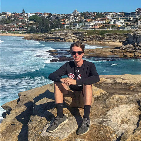 David Brake takes a moment to pose on a beach in Austria. Brake, who spent more than three months at Deakin University in Australia, researched environmentally sustainable practices of major sporting venues in Australia and compared them to venue management practices in the United States.