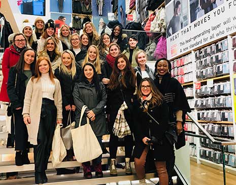Retailing students pose on a staircase with HRSM faculty and staff during a visit to the NRF Big Show, the world's largest retail conference and expo.