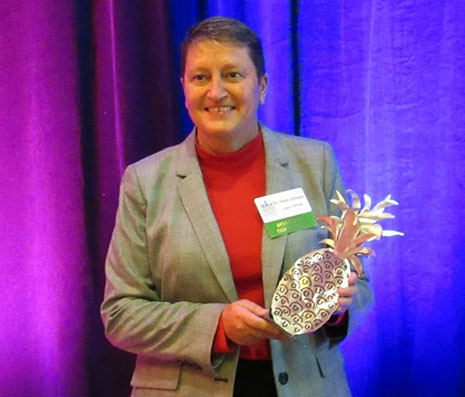 Robin DiPietro holds her SCLRA award, a golden pineapple.
