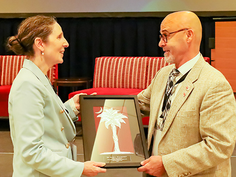Ellen Staurowsky receives the Sonny Vaccaro Impact Award at the CSRI Conference Awards Ceremony, presented to her by Richard Southall, CSRI director