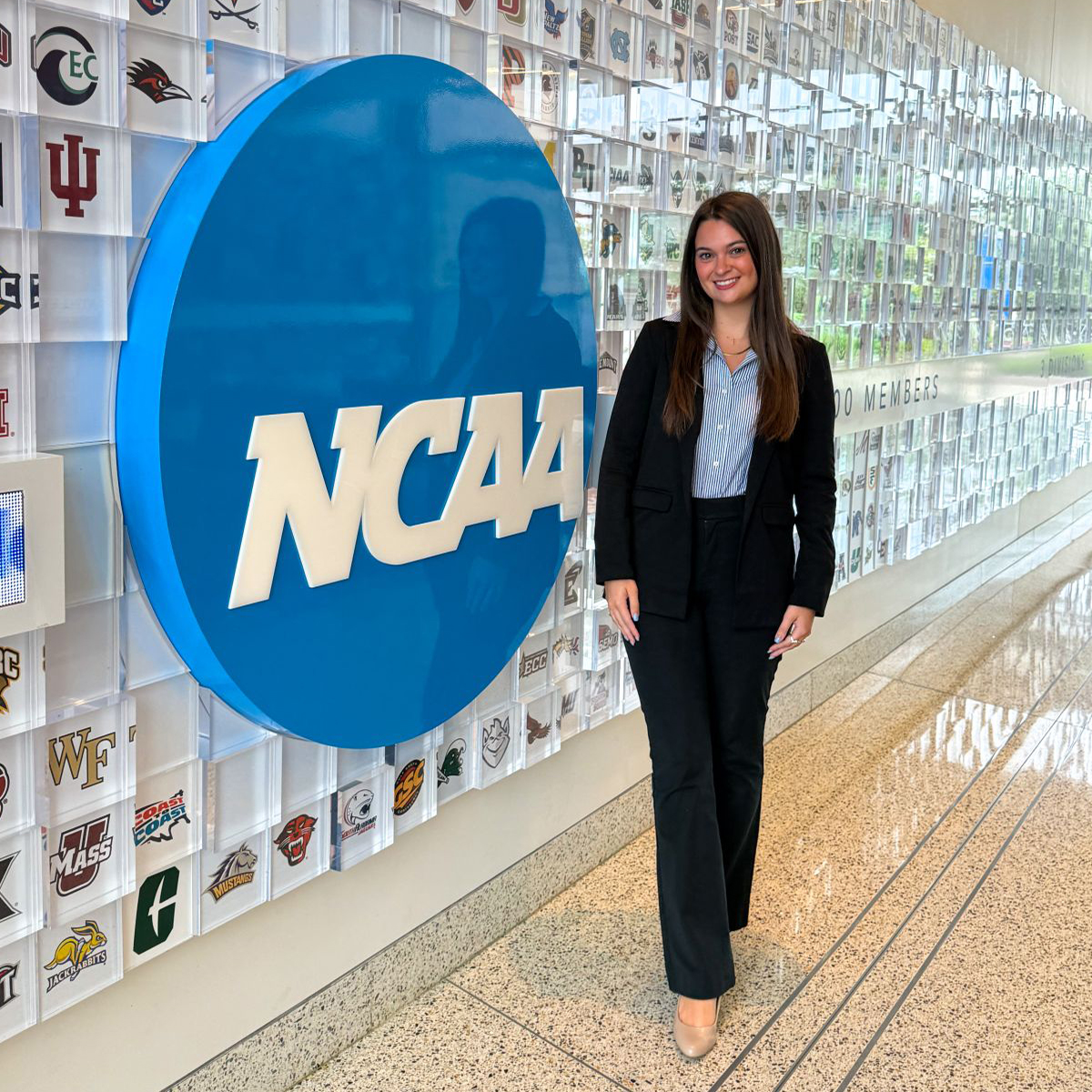 Brycen Ritchie poses by the NCAA logo