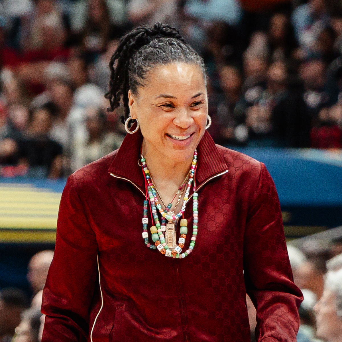 Dawn Staley smiles on the sidelines of a game