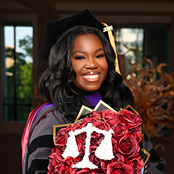 Image of Di'Avian Foster in her cap and gown with roses