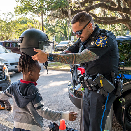 Officer Putting a Helmet on Child