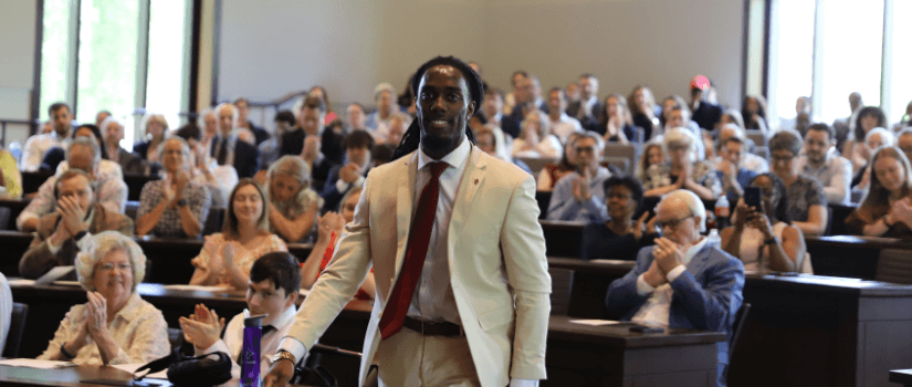 Student walking through crowd to receive an award. 