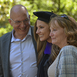 female graduate with her parents after commencement