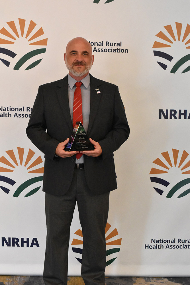 Dr. Kevin Bennett holding an award.