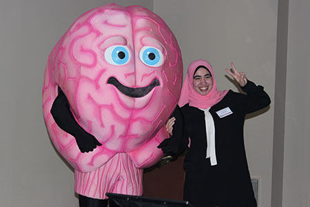 Brain character posing with a woman in a pink headscarf. 