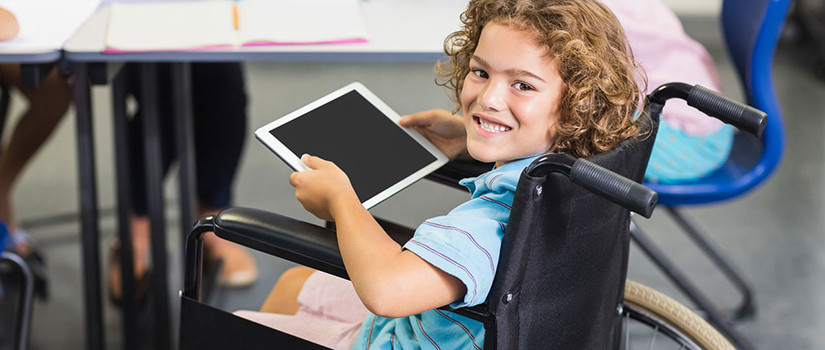 A young girl in a wheelchair holds her tablet