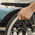 closeup of a hand on the wheel of a wheelchair