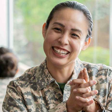 Smiling female army veteran in fatigues.