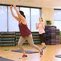 Two women work out in an aerobic exercise studio.