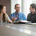 Professor talks with students in conference room