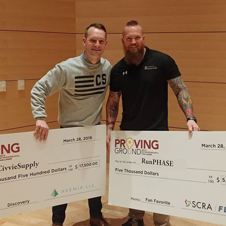 Photo of CivvieSupply and RunPHASE founders holding their 2019 Proving Ground checks