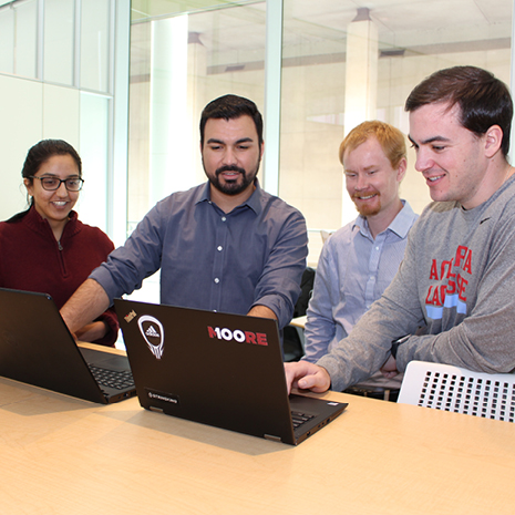 A group of students working on laptops in the Moore Shool's Data Lab