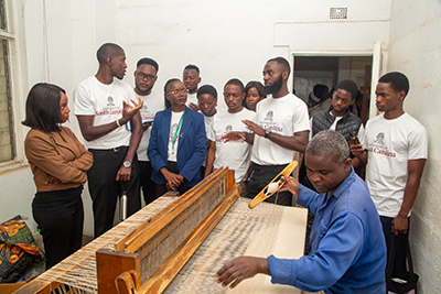 University of Lusaka students learning about fabric creation process from a member of HATTAZ