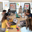 Professor Hildy Teegan overseeing students working on design thinking project