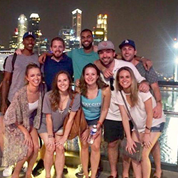 students on study abroad trip posing with cityscape in background