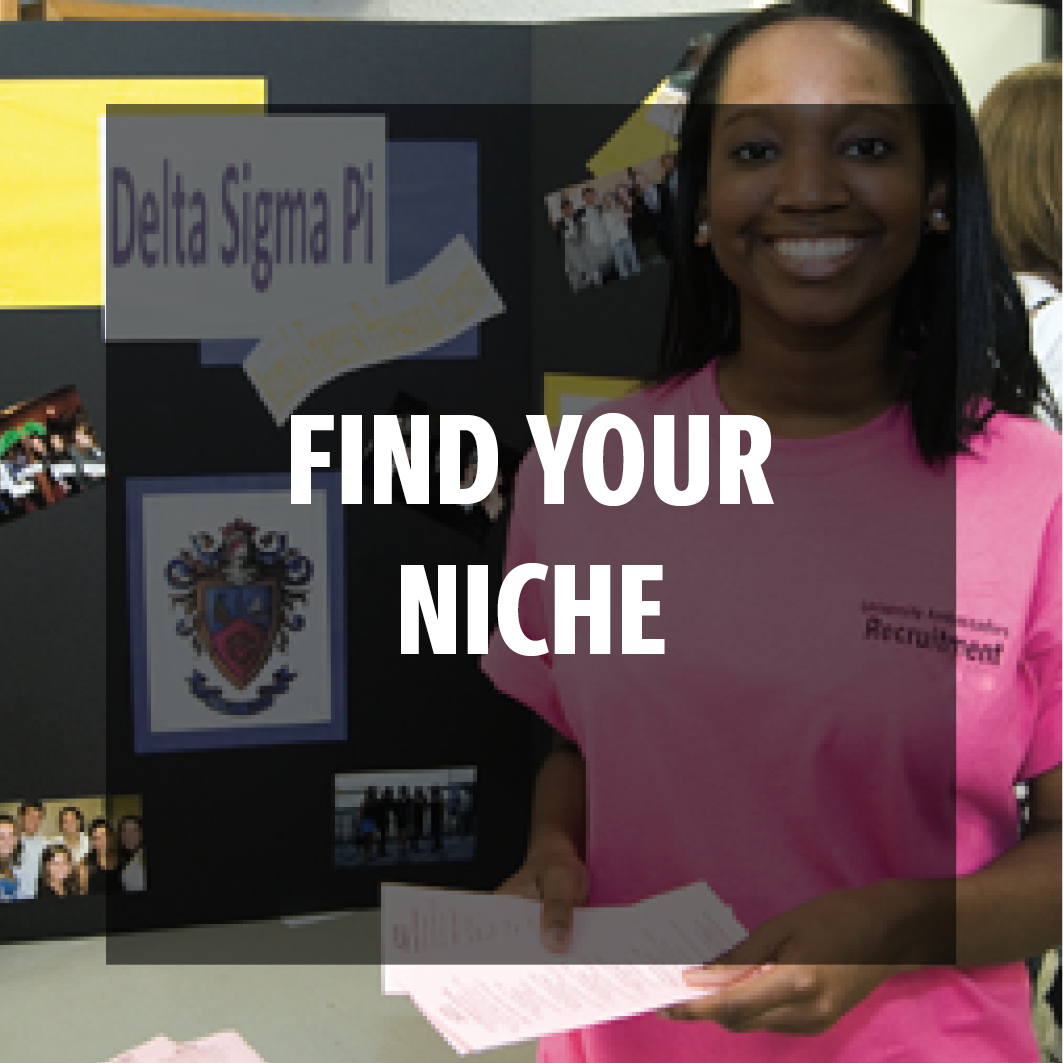 find your niche: female student standing in front of a business fraternity display