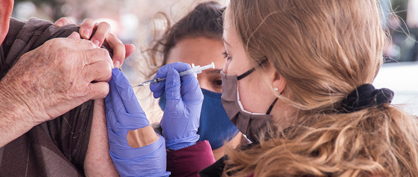 student giving covid vaccine 