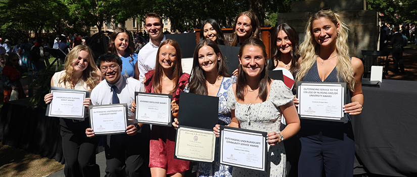 Nursing students holding their awards on stage outside on the Horseshoe