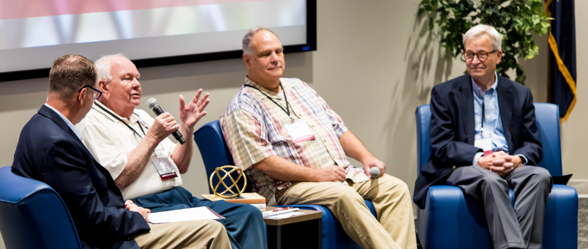 Panelists on stage at a conference